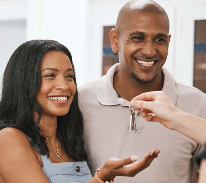 couple grabbing keys to their new home